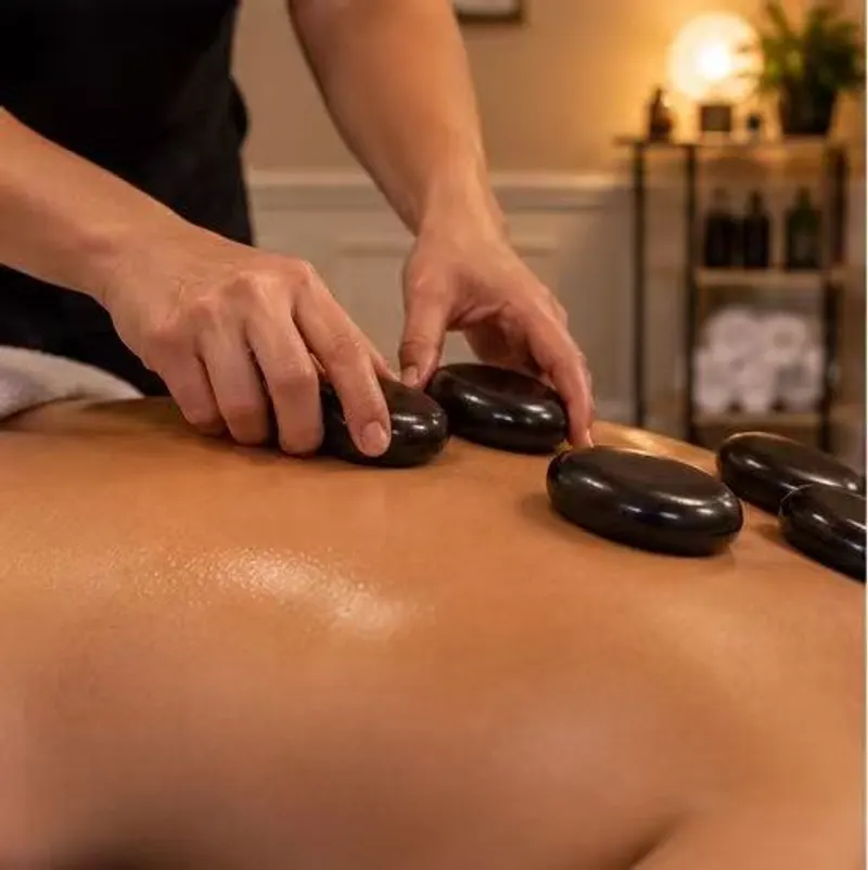 Therapist using smooth hot stones on a guest’s back